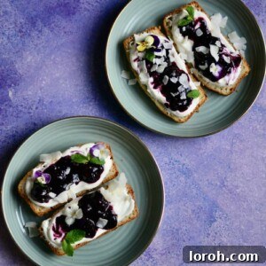Delicious Banana Bread with Homemade Berry Jam and Greek Yogurt, garnished with edible flowers and toasted coconut flakes