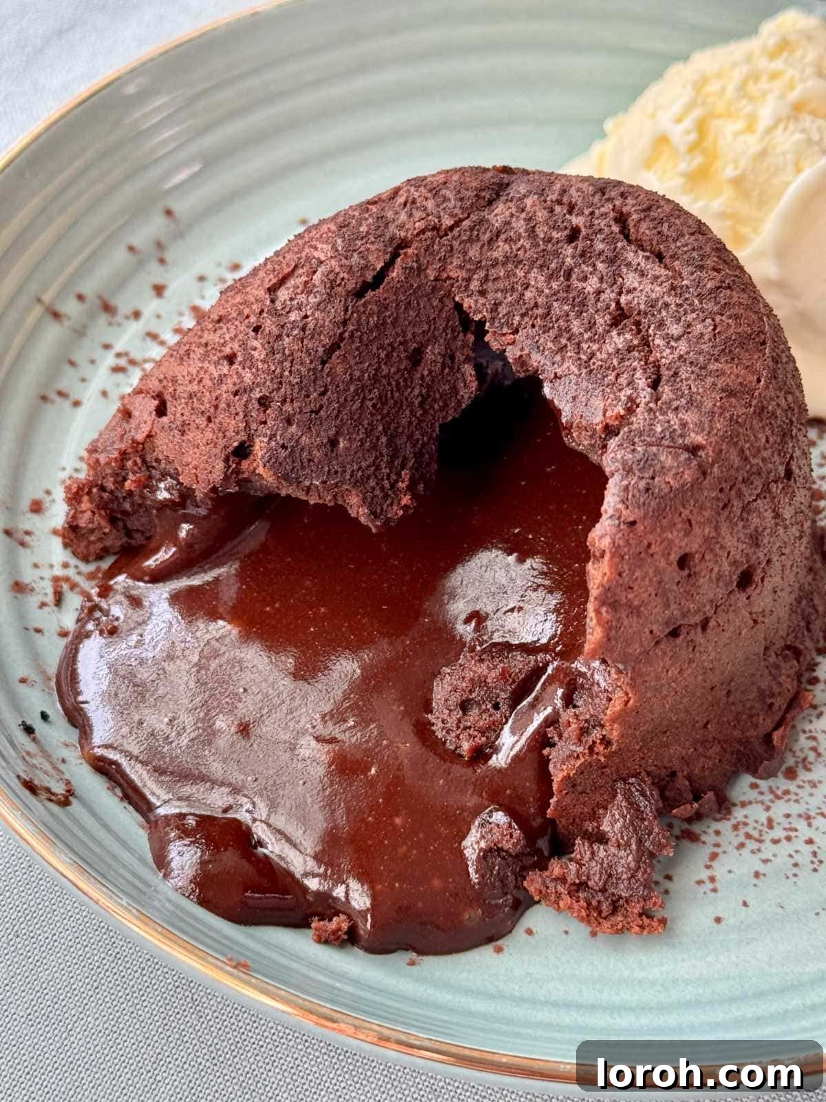Molten Lava Chocolate Pudding 2 Exquisite melt-in-the-middle chocolate pudding on a white plate, revealing a molten chocolate center.
