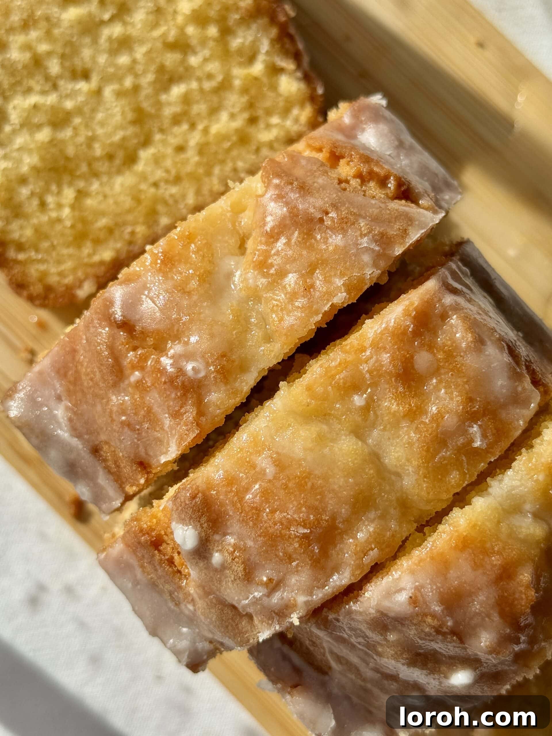 Sunshine Lemon Loaf 12 A close-up shot of the perfectly baked lemon loaf cake with its generous, glistening lemon drizzle, ready to be enjoyed.