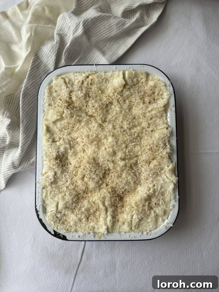 Effortless Lasagna with Shortcut White Sauce 2 A rectangular dish of lasagne, before baking with a thick layer of grated cheese on top, ready for the oven