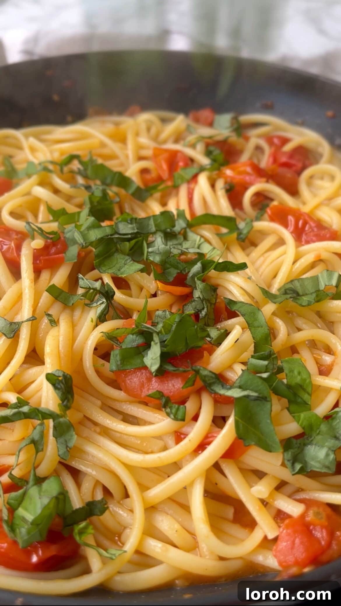 Bursting Burrata Tomato Pasta 7 Adding fresh basil to the Burrata Pasta in the pan.