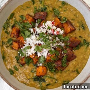 A bowl of Anna Jones's Dal with Crispy Sweet Potatoes and Coconut Chutney, garnished with fresh cilantro.