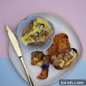 Elegantly presented chicken liver paté on toast, garnished with herbs