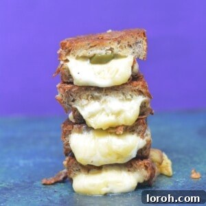 A perfectly golden-brown toasted cheese sandwich with melted cheese oozing out, signifying ultimate comfort food.