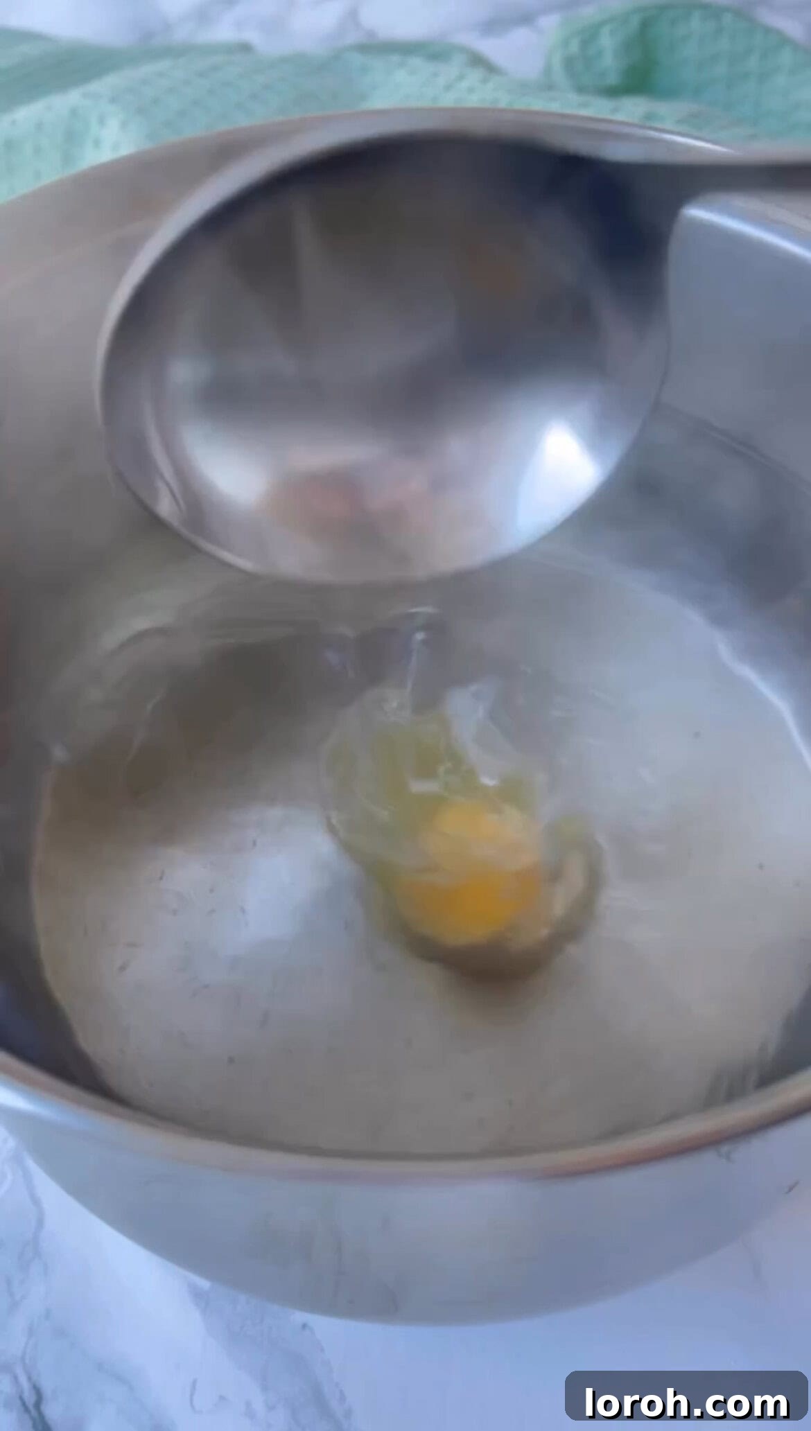 Delicately poaching an egg for Turkish Eggs, ensuring a perfect runny yolk