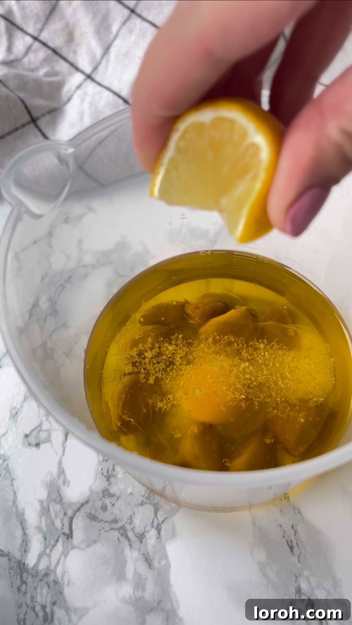 adding lemon and egg to make roasted garlic aioli