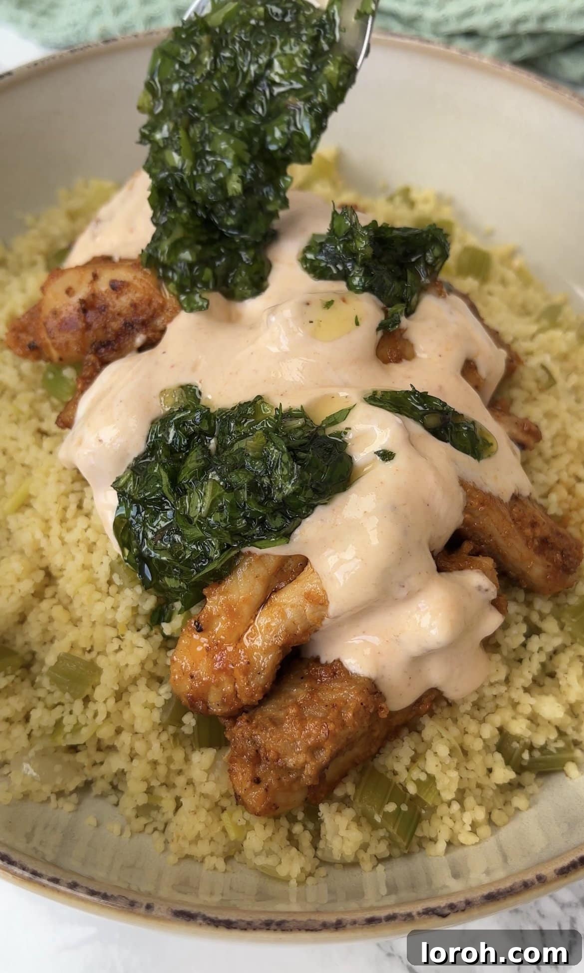 Fiery Harissa Chicken and Speedy Couscous 11 Assembled harissa chicken and couscous topped with herby drizzle and a dollop of harissa yoghurt.
