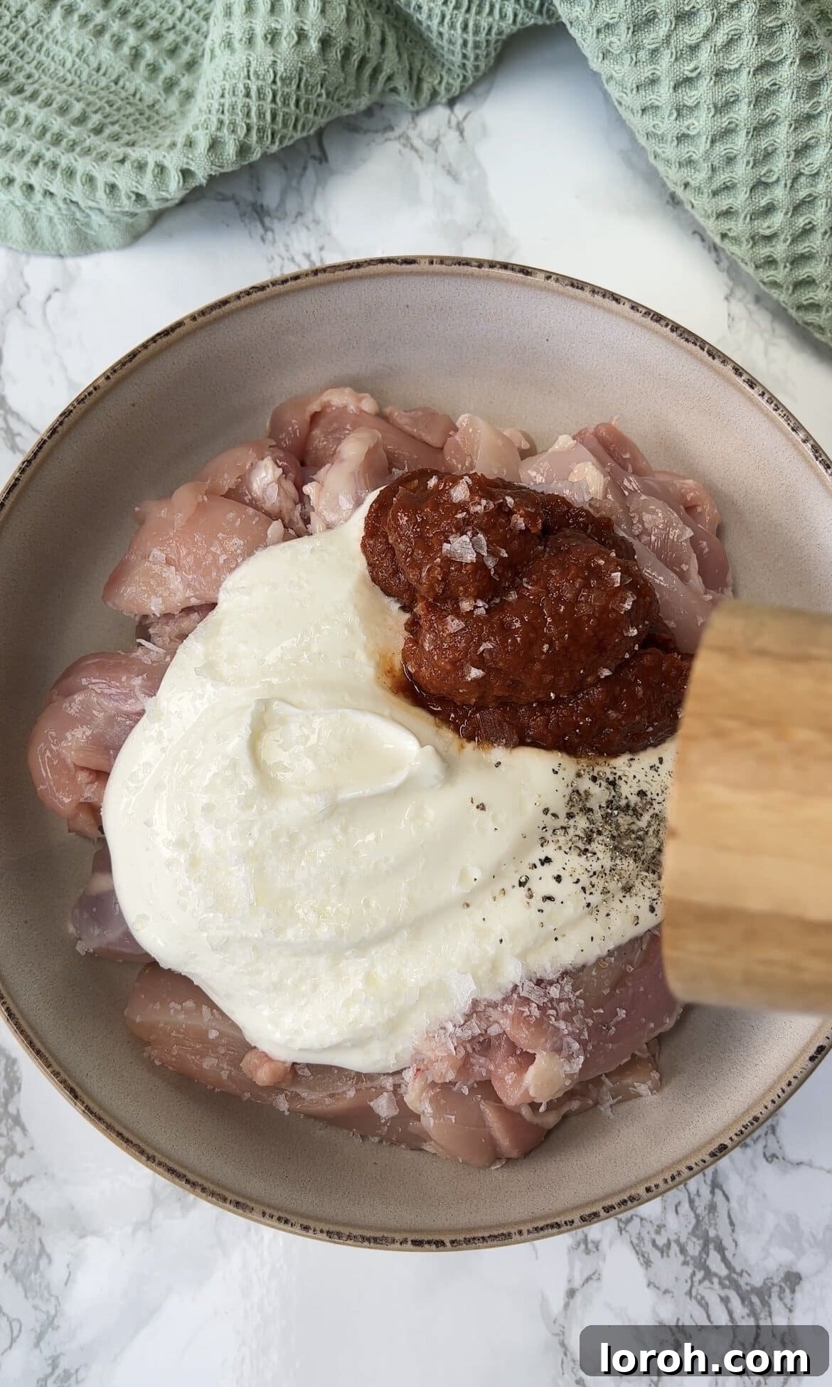 Fiery Harissa Chicken and Speedy Couscous 4 Slicing chicken thighs and marinating with yogurt and harissa paste in a bowl.