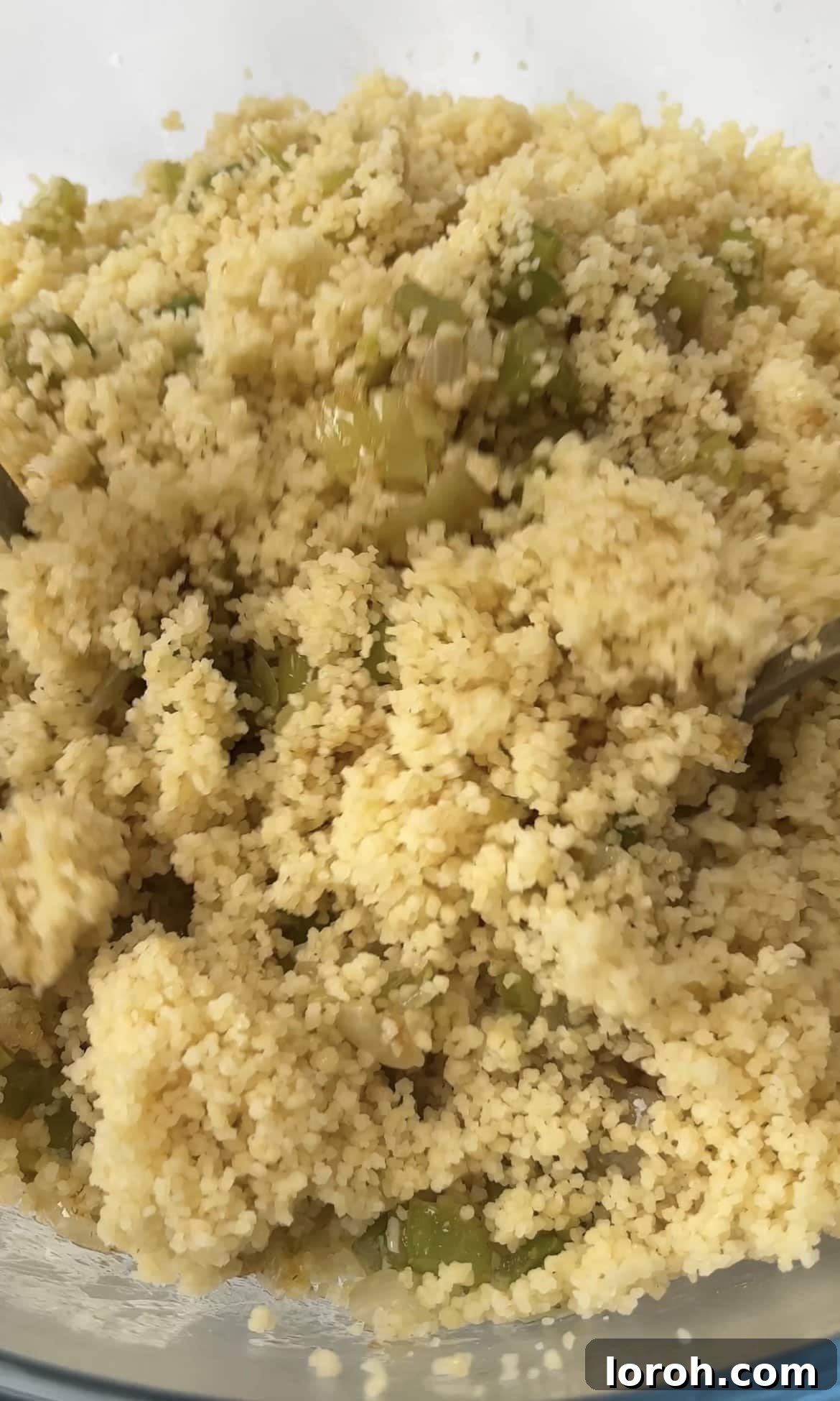Fiery Harissa Chicken and Speedy Couscous 9 Fluffing up the cooked couscous with a fork in a large bowl.