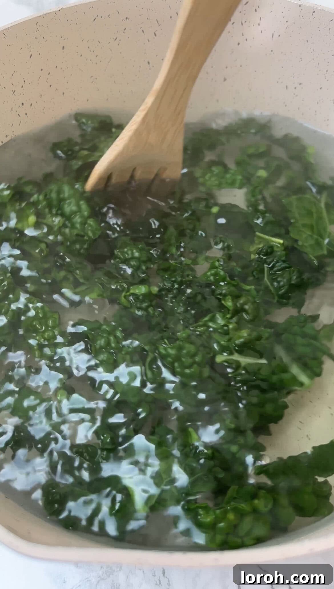 Roughly chopped cavolo nero leaves boiling in a small pot of generously salted water.