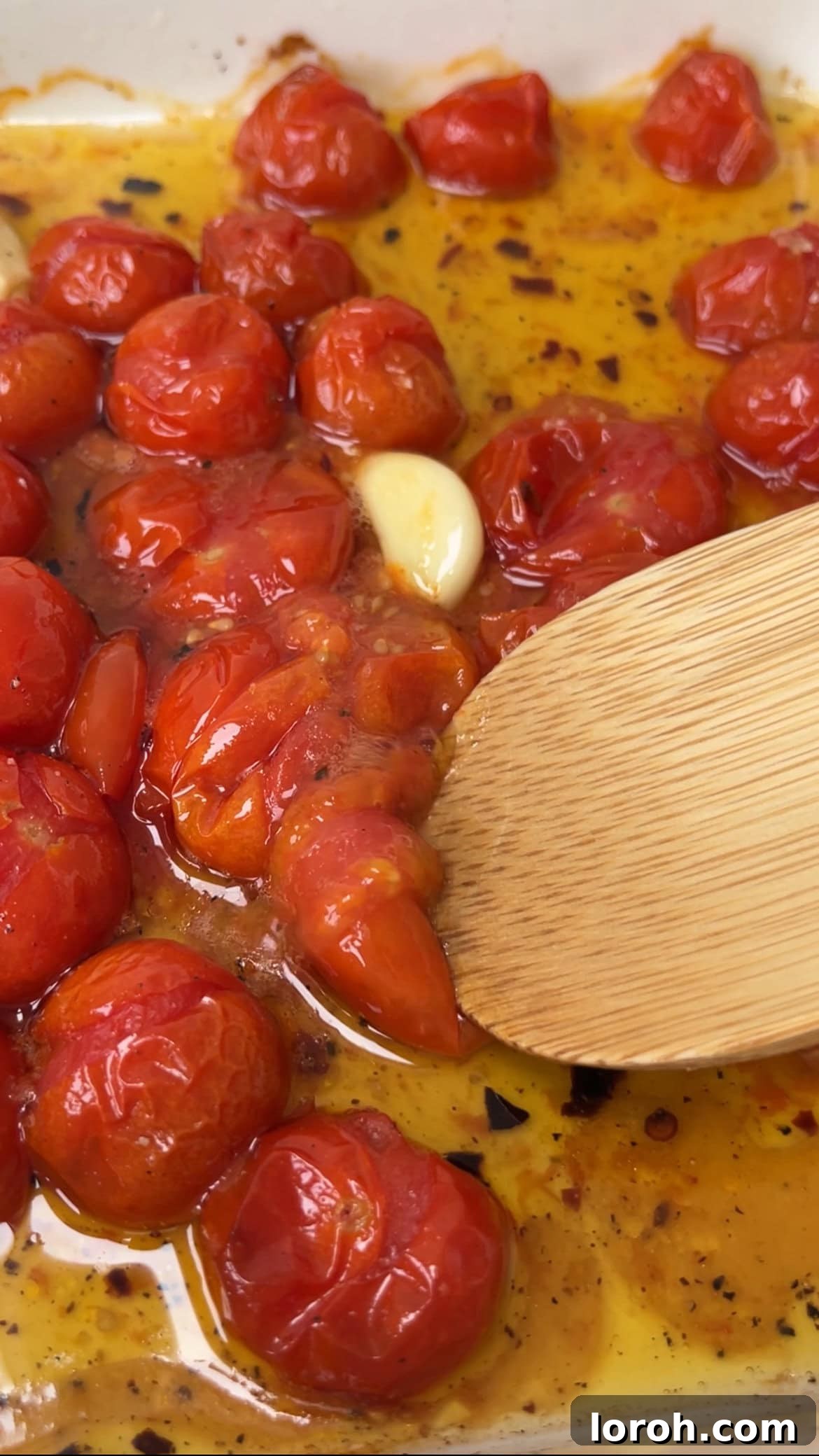 Velvety Tomato Mascarpone Orzo 5 using the back of a spoon to mash the roasted tomatoes and garlic into a sauce.