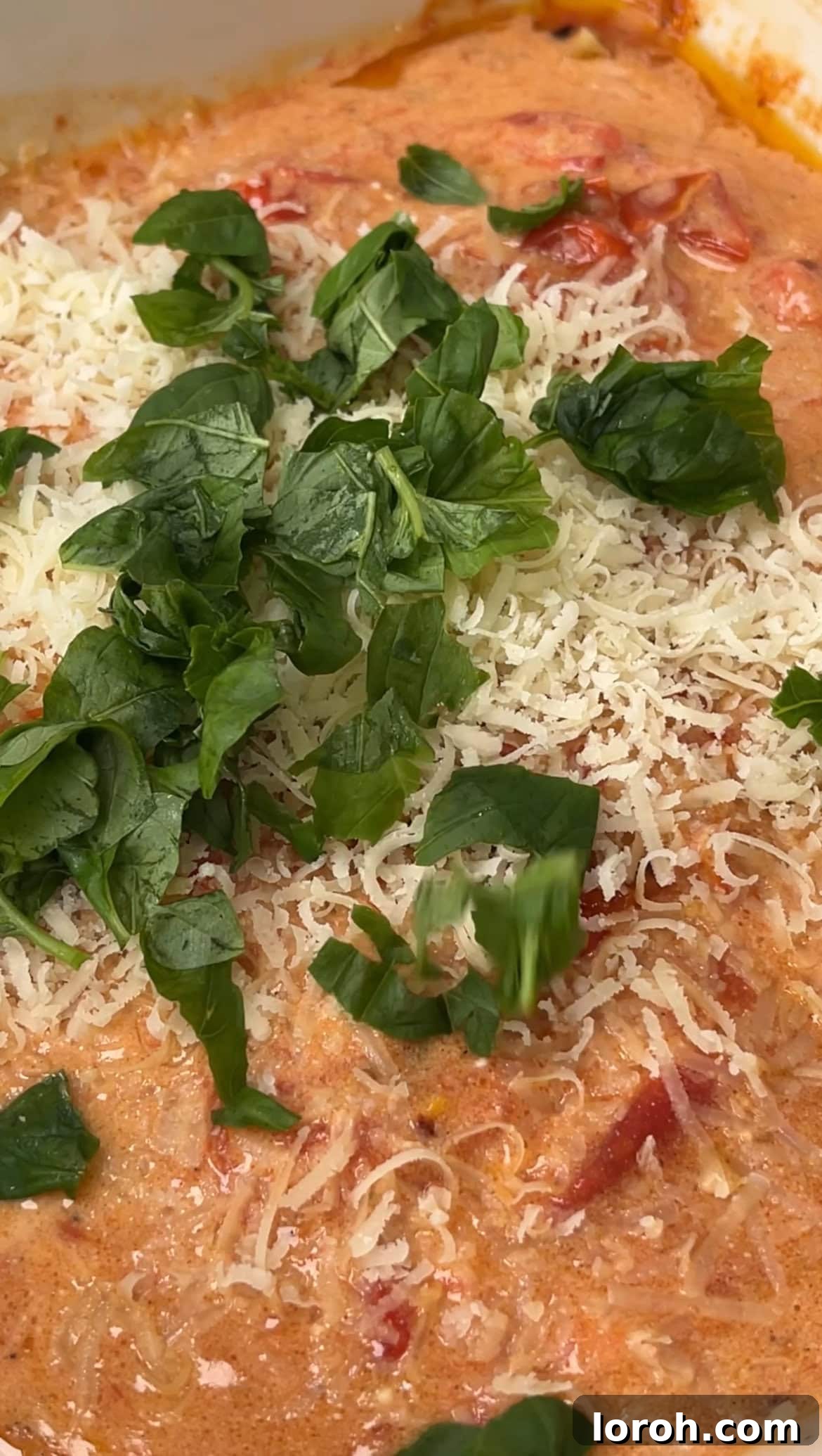 Velvety Tomato Mascarpone Orzo 7 adding grated parmesan and fresh basil to the creamy tomato sauce.