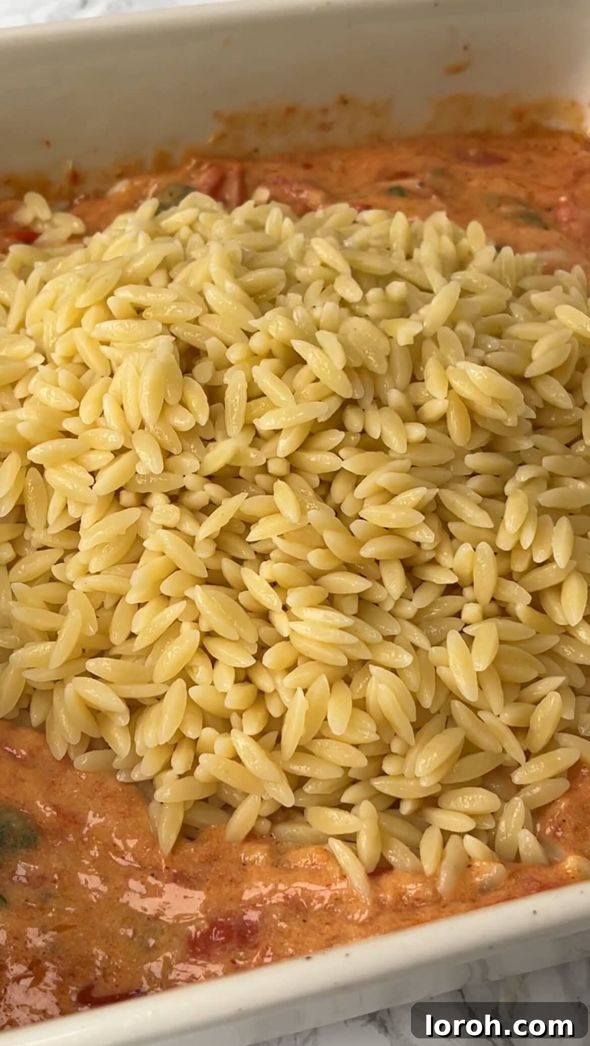 Velvety Tomato Mascarpone Orzo 8 adding cooked orzo to the tomato and mascarpone sauce in a roasting dish.
