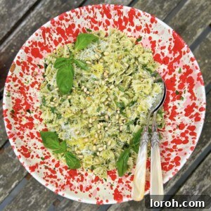 Vibrant Basil Pesto Pasta Salad with fresh basil leaves, pine nuts, and parmesan shavings