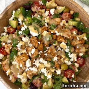 Vibrant Greek Summer Chicken Salad 2 Close-up of a vibrant Greek Chicken Summer Salad with golden chicken pieces, fresh vegetables, feta, and olives.