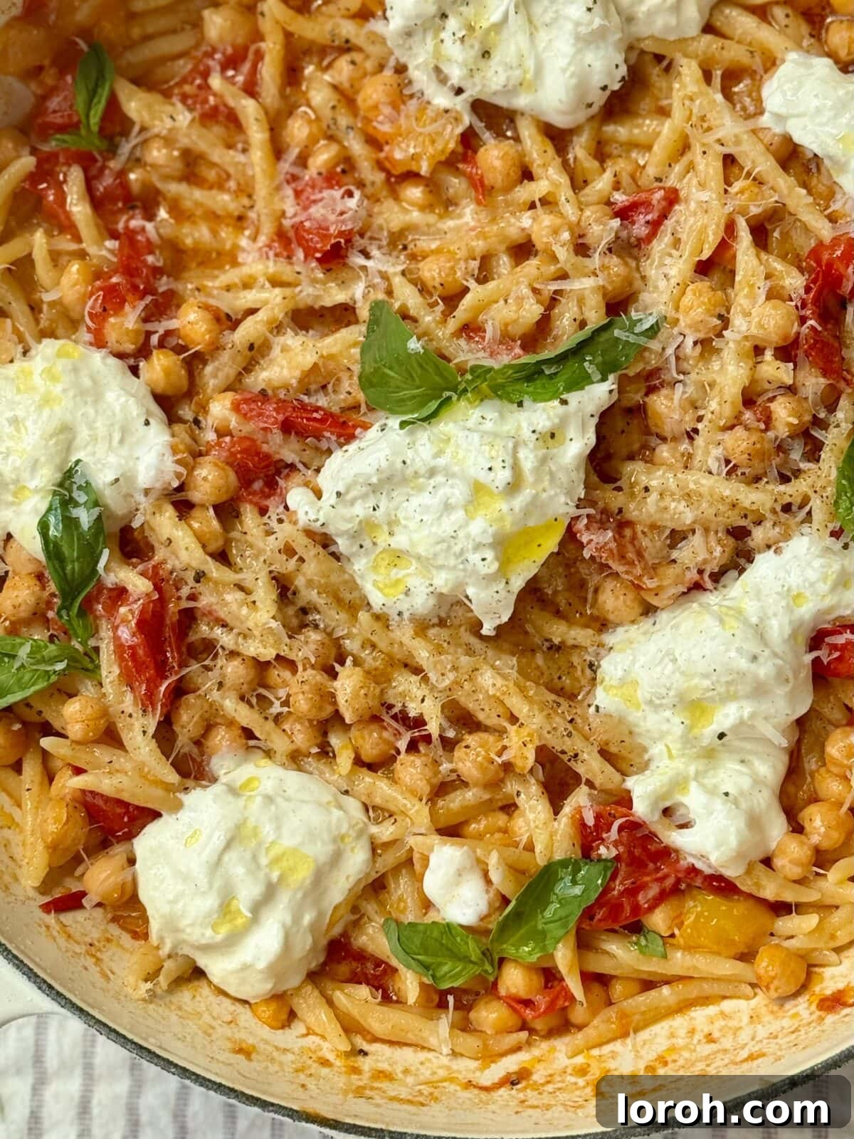 Close-up of trofie pasta in a pan with mozzarella and tomato sauce, ready to be served.