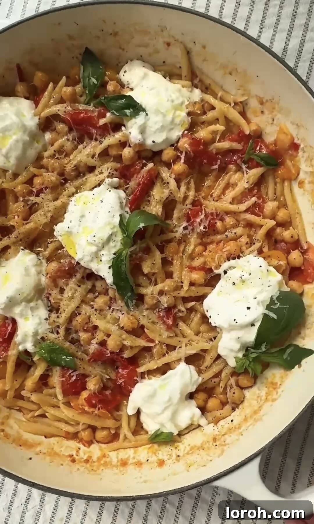 A pan of trofie pasta with tomato, chickpeas, and mozzarella, ready for serving.