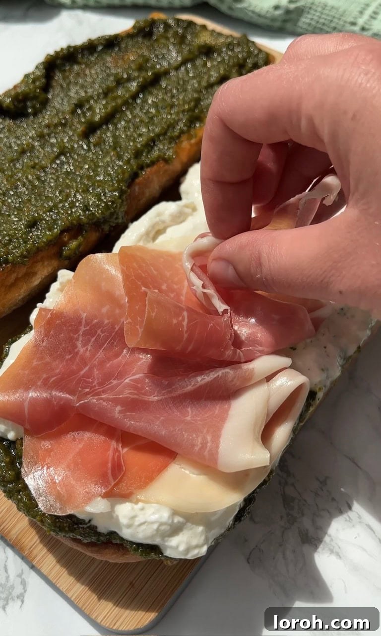 Burrata Caprese Prosciutto Sandwich Drizzled with Pistachio Pesto 10 Arranging delicate ribbons of Parma ham on top of the creamy burrata.