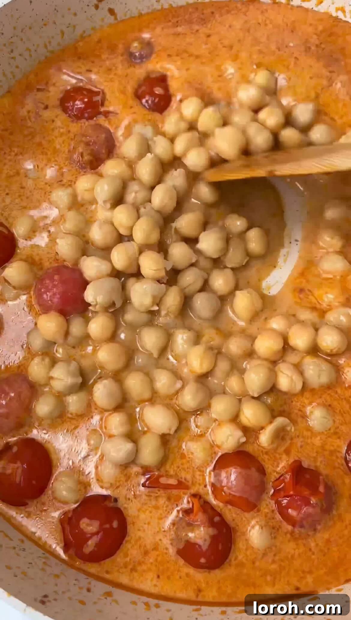 Adding chickpeas, coconut milk, lime, and fish sauce to the fragrant curry base for simmering.