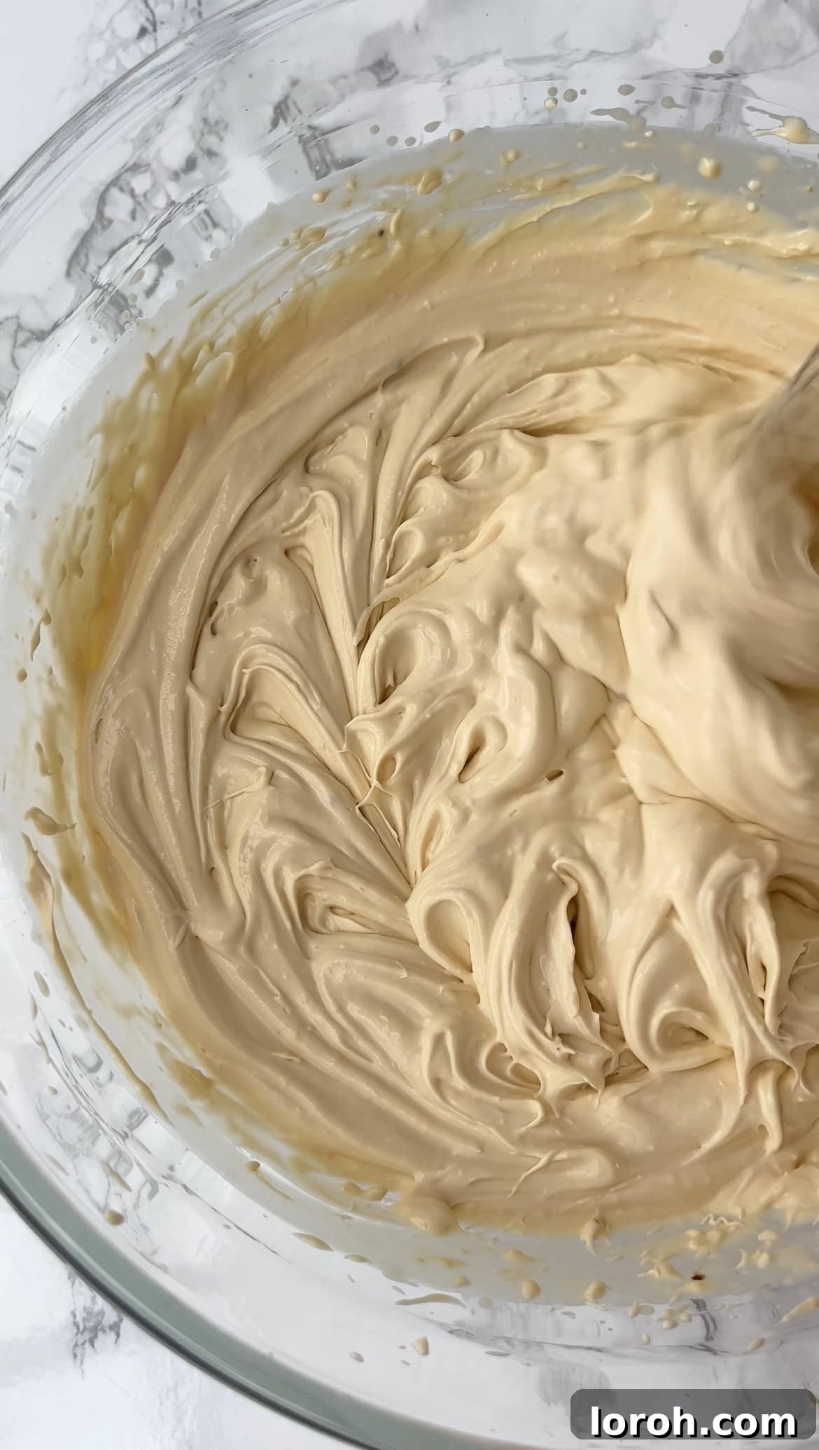 Whipping the ice cream mixture with an electric whisk until thick and fluffy.