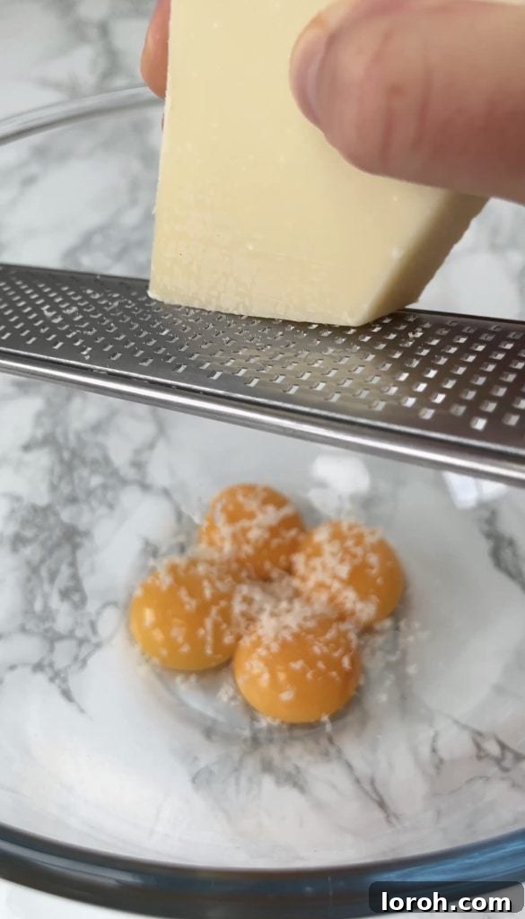 Carbonara, Elevated by Guanciale 6 grating parmesan into eggs - carbonara with guanciale