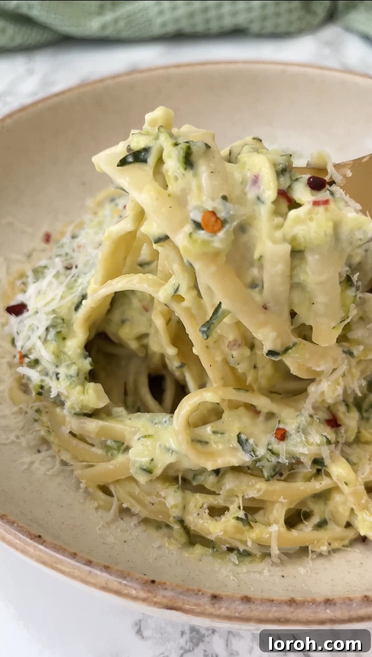 A close-up of the finished creamy courgette pasta, showcasing the vibrant green courgettes and rich sauce, ready for serving.