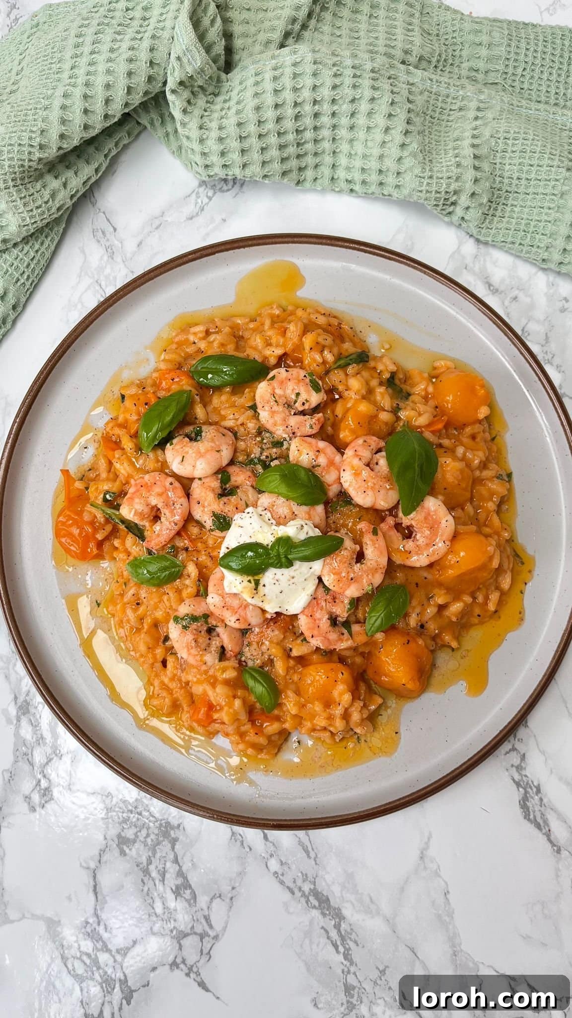 Creamy tomato mascarpone risotto generously topped with smoky garlic butter prawns and fresh basil.