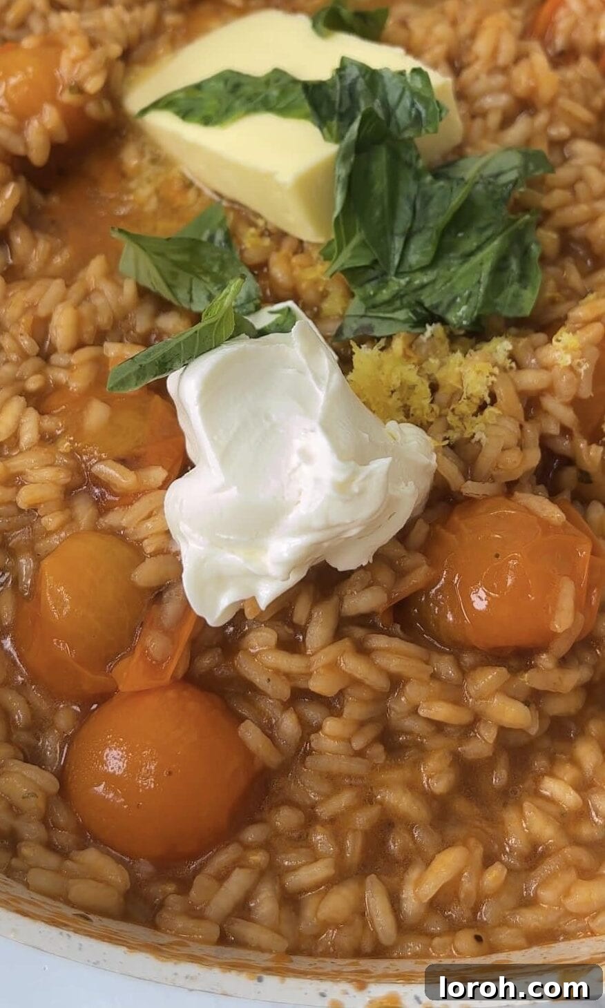 Finishing creamy tomato mascarpone risotto with a knob of butter and fresh basil.