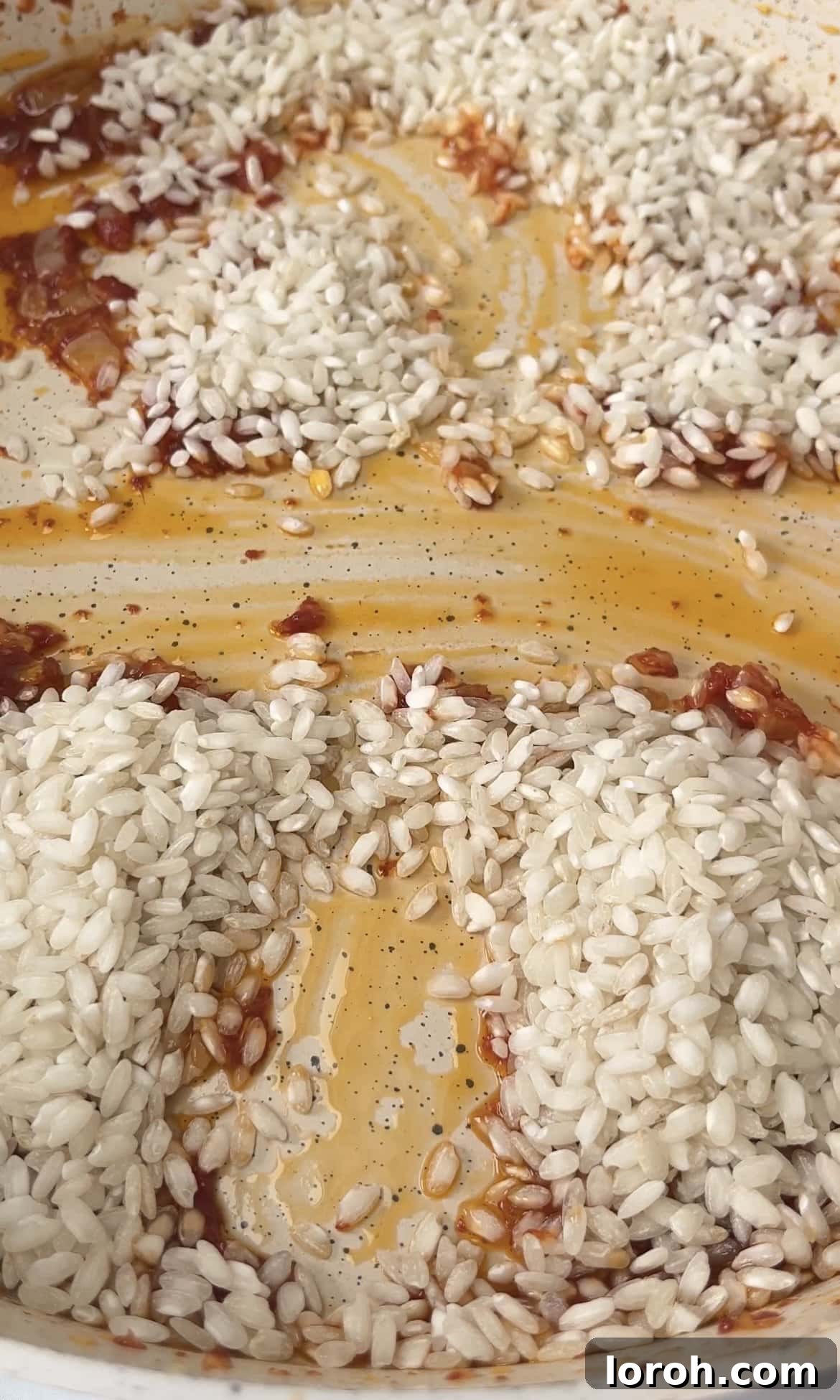 Toasting arborio rice in a pan, preparing it for the gradual addition of stock.