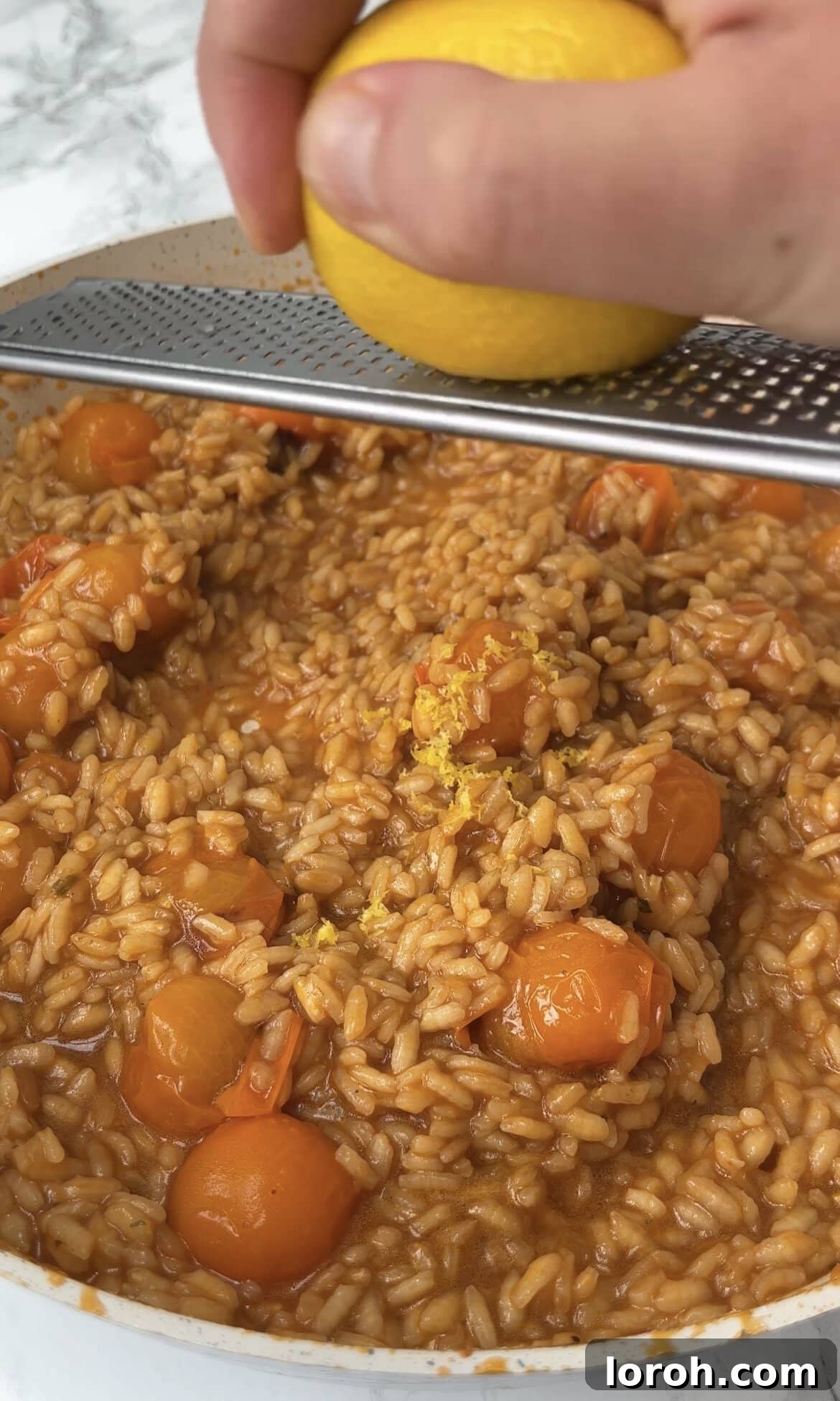 Stirring lemon zest into the creamy tomato mascarpone risotto.