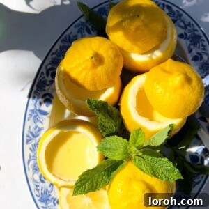 lemon possets in scooped out lemon halves on a blue plate.
