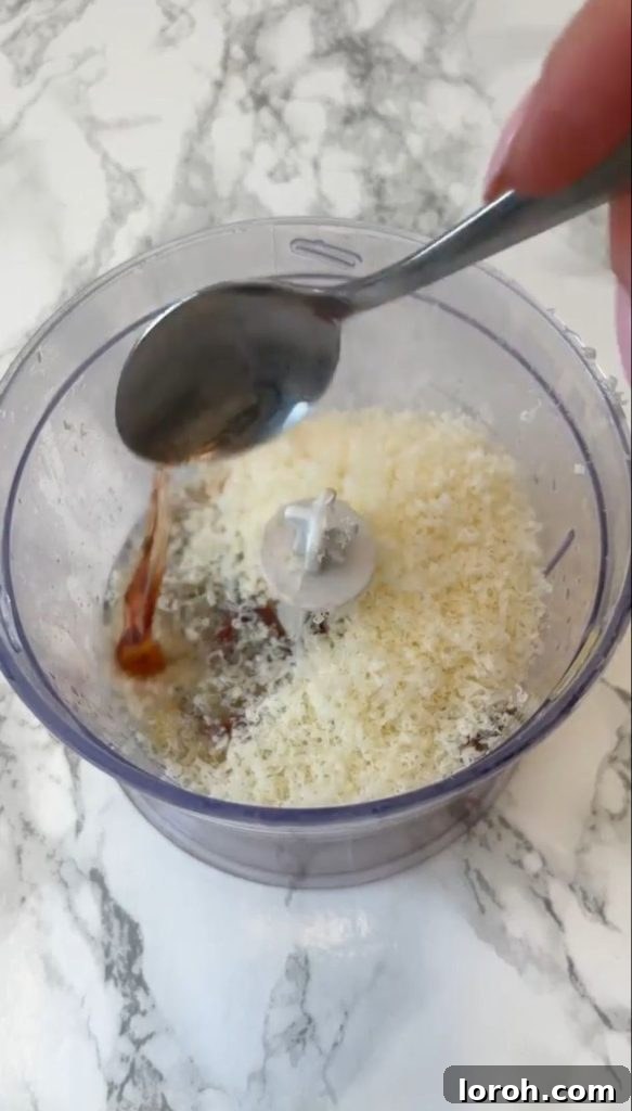 Adding red wine vinegar to a blender with egg yolks, lemon, garlic, and Worcestershire sauce