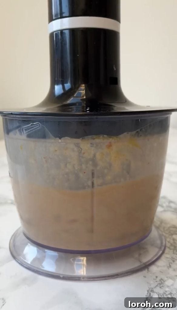 Blender filled with a perfectly creamy and smooth caesar salad dressing