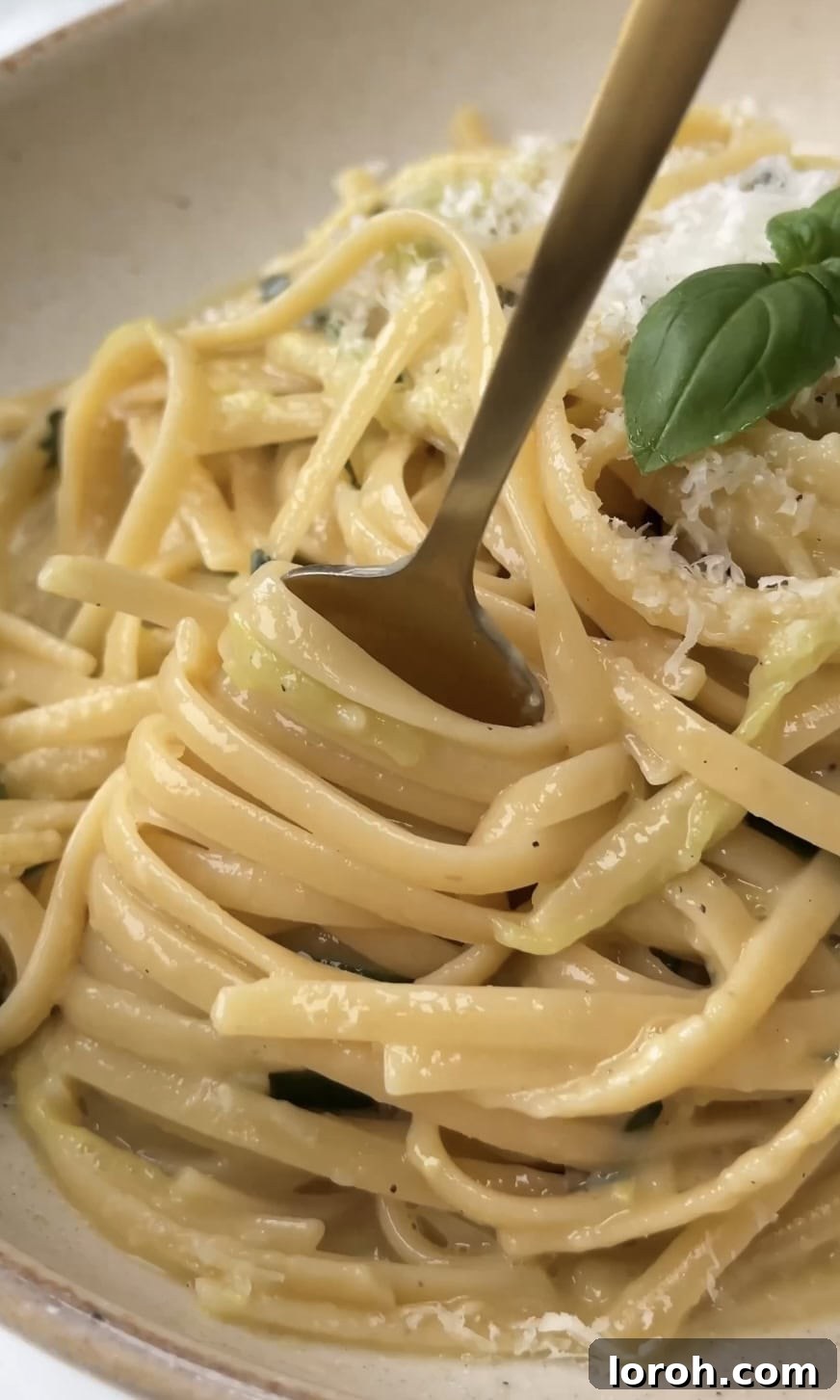 Close-up of fresh zucchini ribbons and grated Pecorino cheese for Lemony Courgette Carbonara.