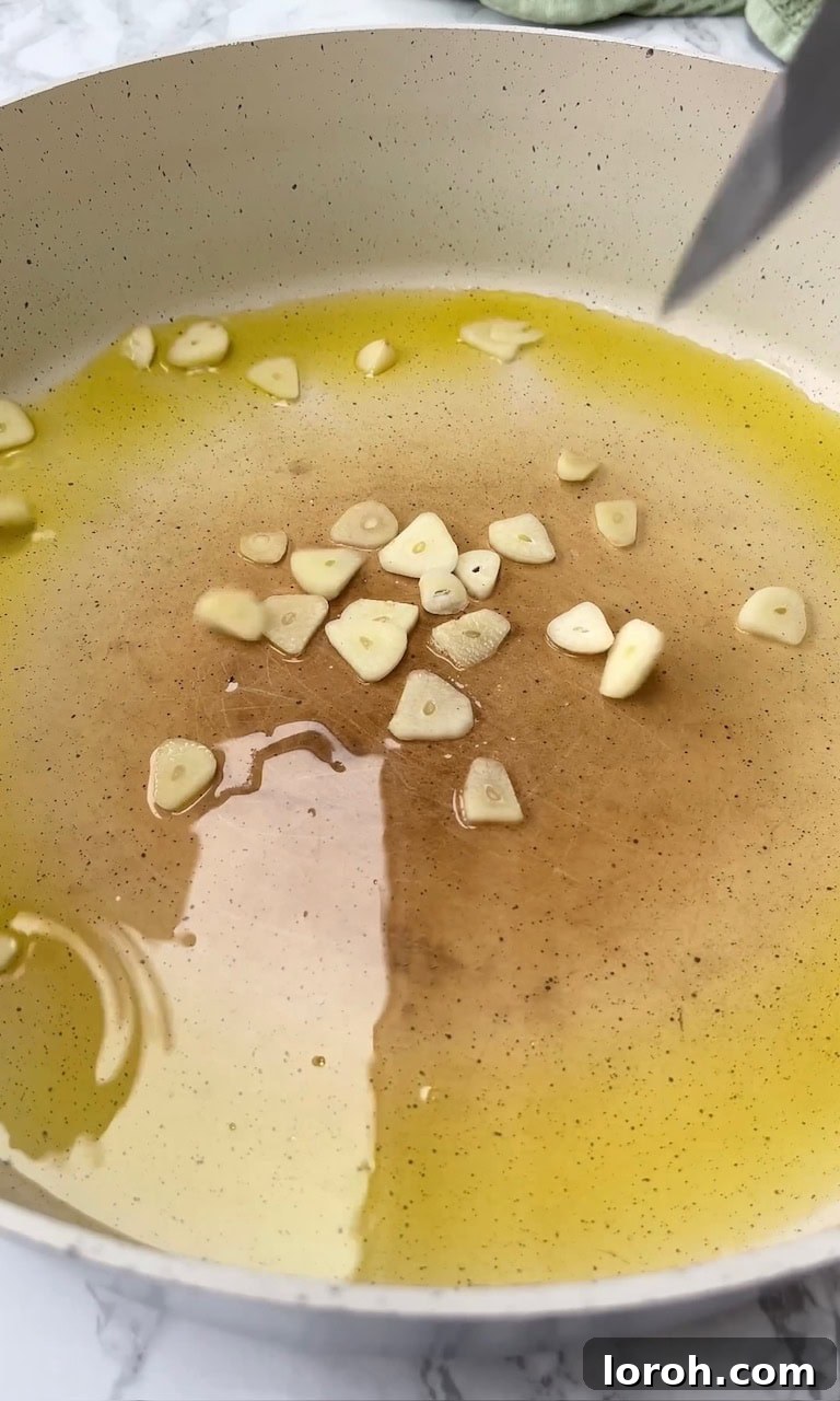 Frying finely sliced garlic in a pan with olive oil.