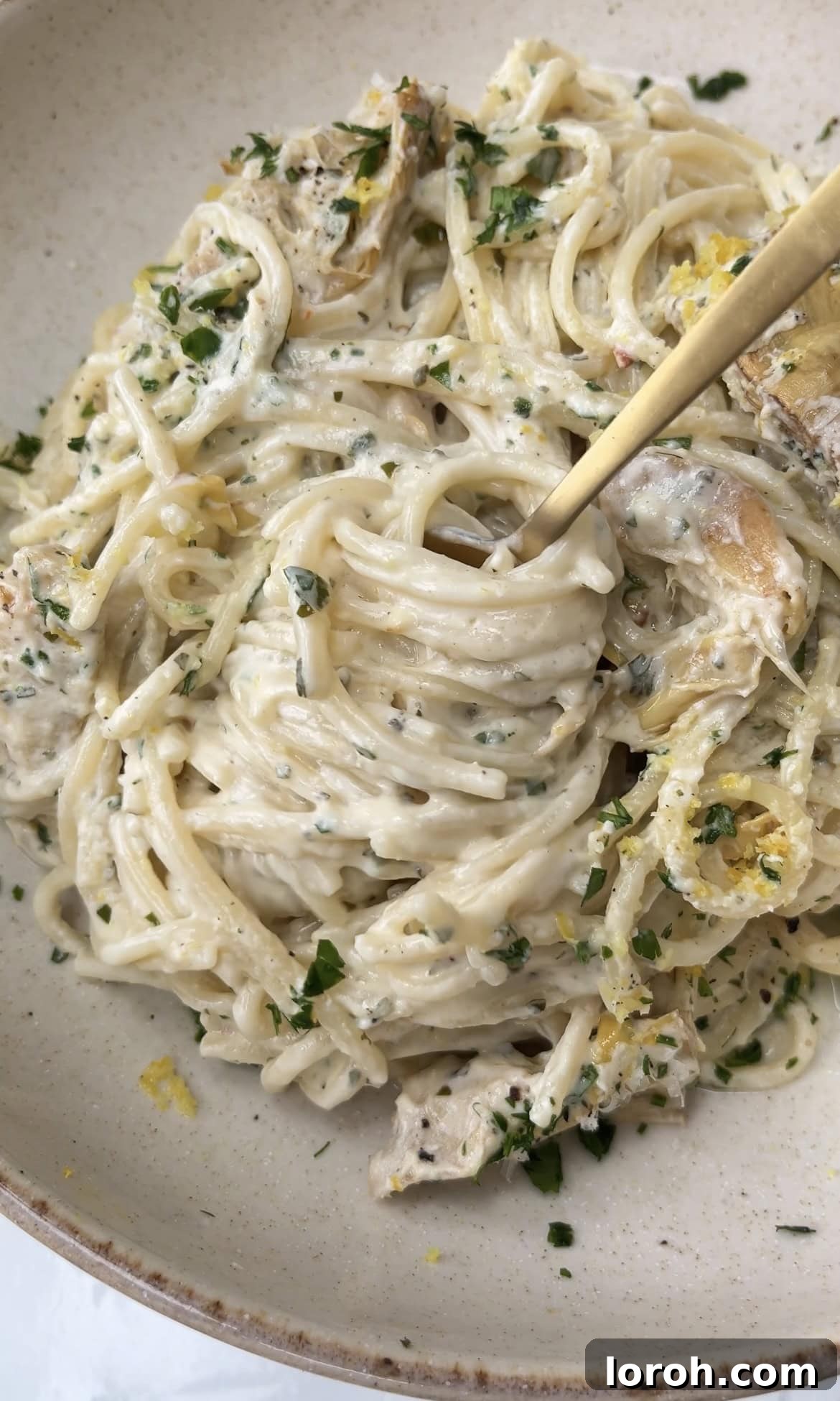 Creamy Lemon Artichoke Boursin Pasta Bake 10 A fork twirling a generous portion of creamy Baked Boursin Pasta with lemon and artichokes, ready to be enjoyed.