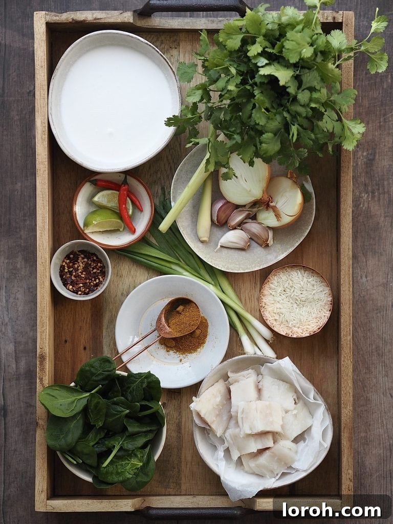 Ingredients to make a fish curry on a wooden tray.