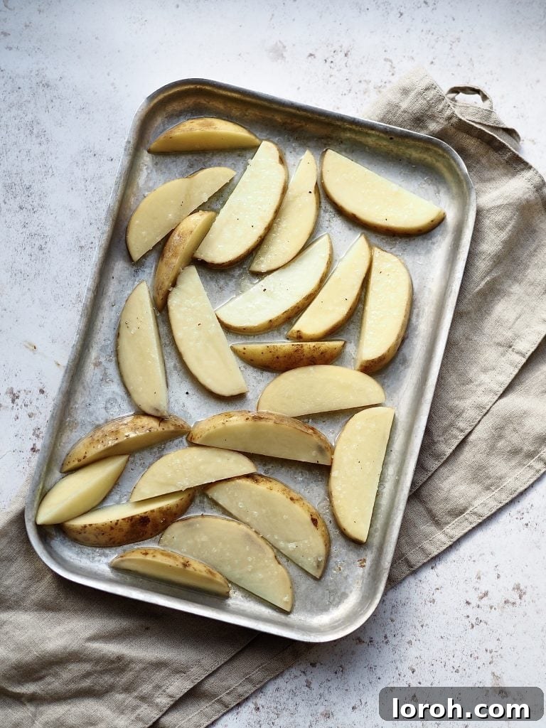 Golden Crispy Cod with Tartar Zing 3 Tray of uncooked potato wedges tossed in olive oil.
