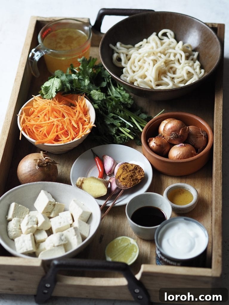 Ingredients to make a udon soup on a wooden tray.