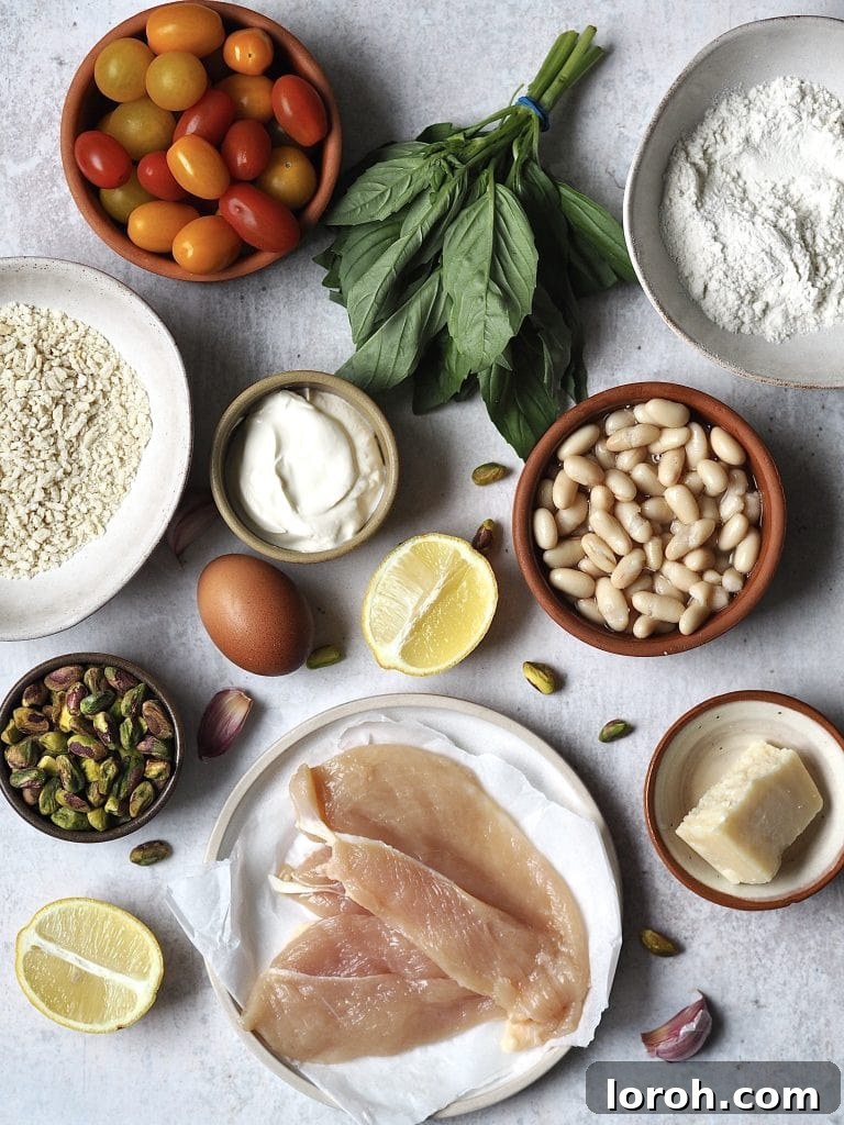 Crispy Chicken with Mediterranean White Bean Salad 4 Ingredients for Crispy Baked Chicken with Tomatoes, Basil and Cannellini Beans on a grey background.