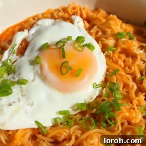 Korean Spicy Ramen Noodles with cheese and a fried egg on top, presented in a bowl ready to eat.