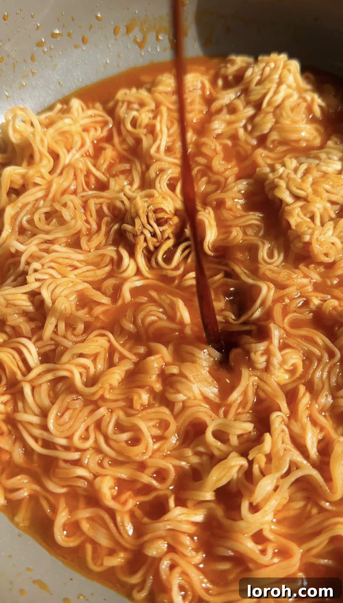 Korean Fire Cheese Noodles 8 Adding grated mozzarella cheese to the hot Korean spicy ramen noodles, ready to melt into a creamy sauce.