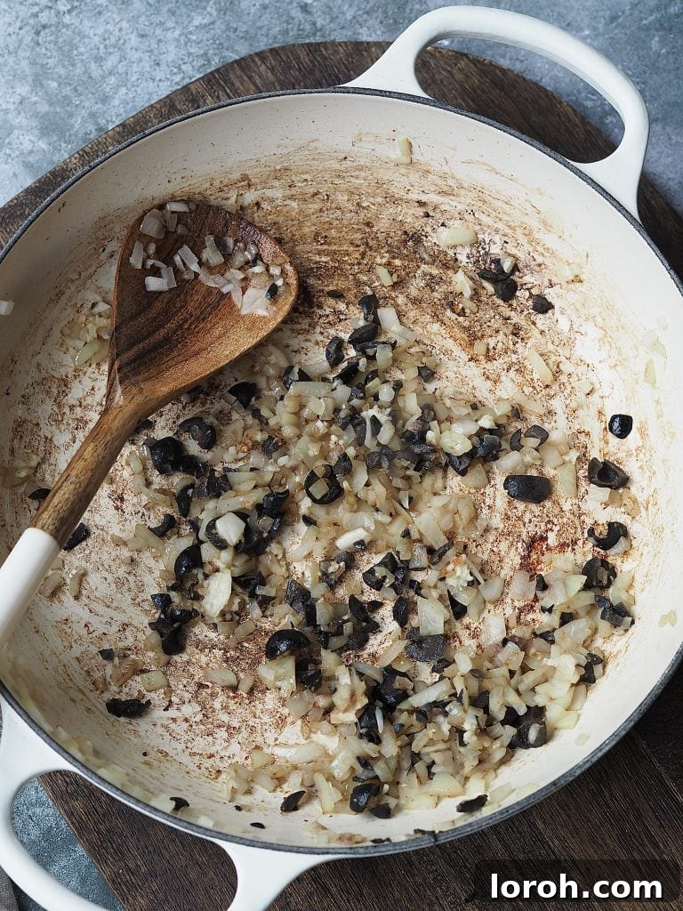 Bold Penne Puttanesca 6 Frying onions, anchovies, and chopped black olives in a shallow casserole dish, creating a rich aromatic mixture.