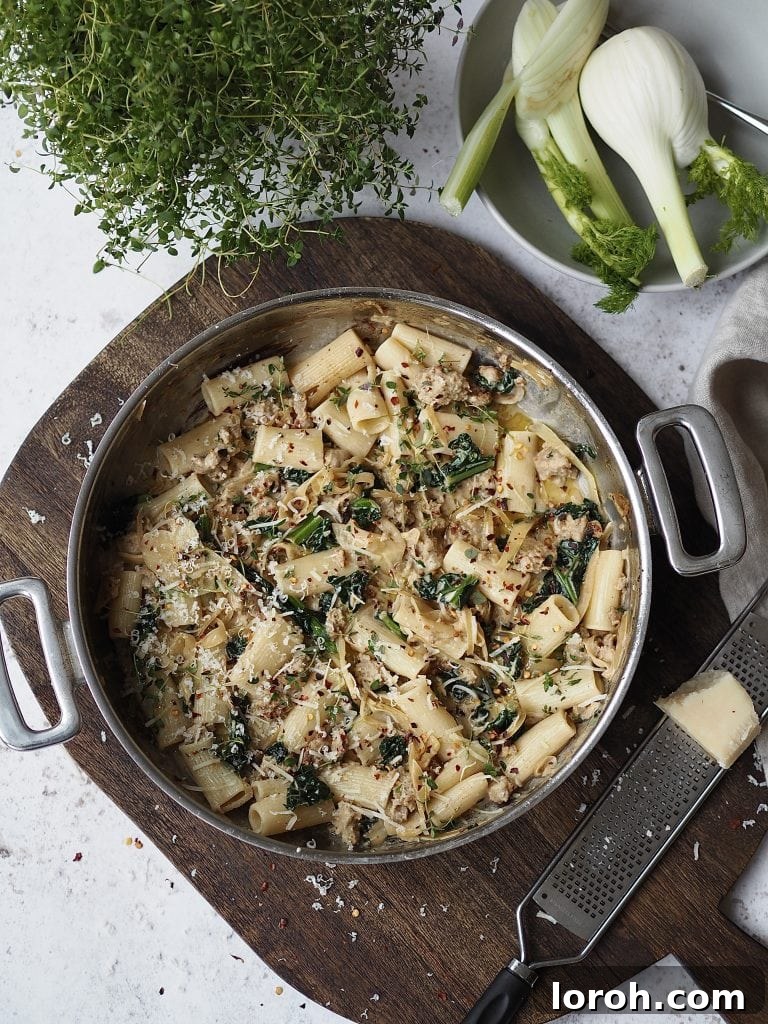 Chili-Fennel Sausage Rigatoni with Tuscan Kale 2 Cooking pot filled with creamy sausage and kale pasta on a wooden board.