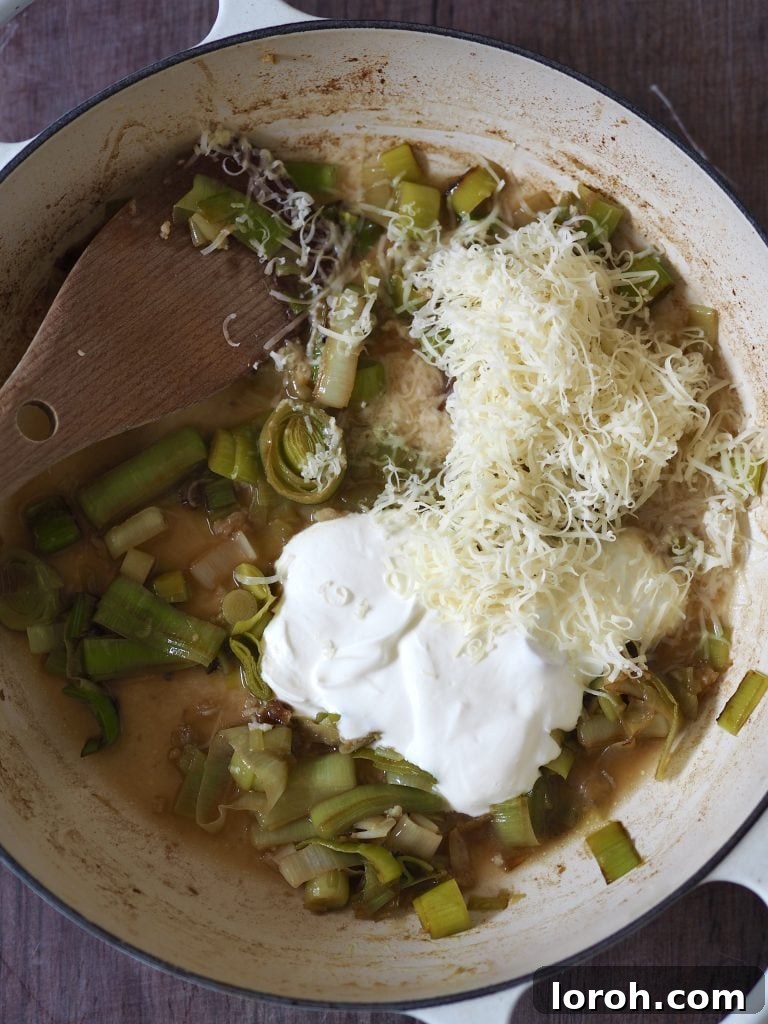 Velvety Caramelized Leek & Gruyère Pasta 8 Grated cheese and creme fraiche being stirred into slow cooked leeks.