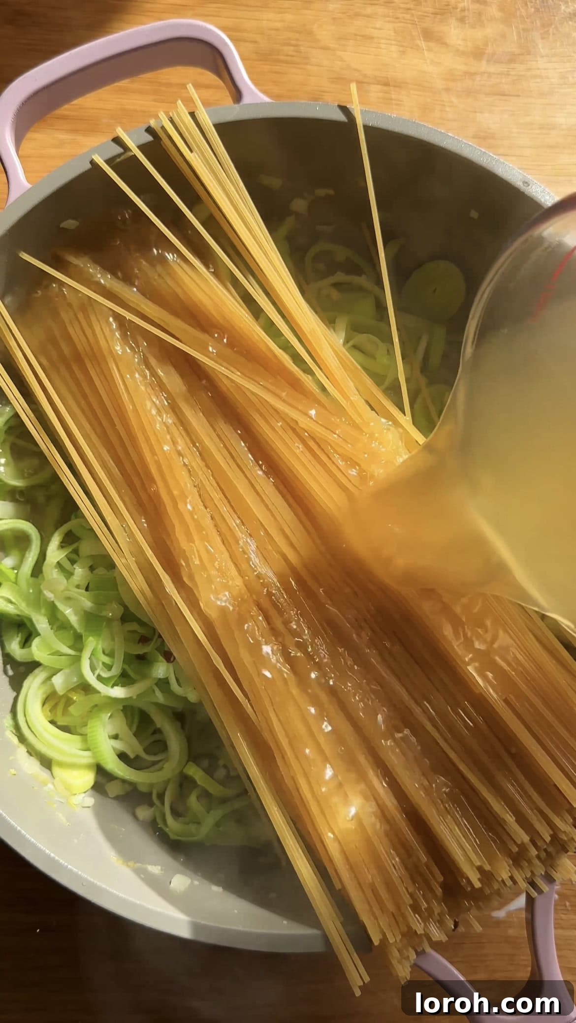 Sizzling Parma Ham & Leek One-Pan Pasta 5 Adding chicken stock to spaghetti and creamy sauce in a large saucepan