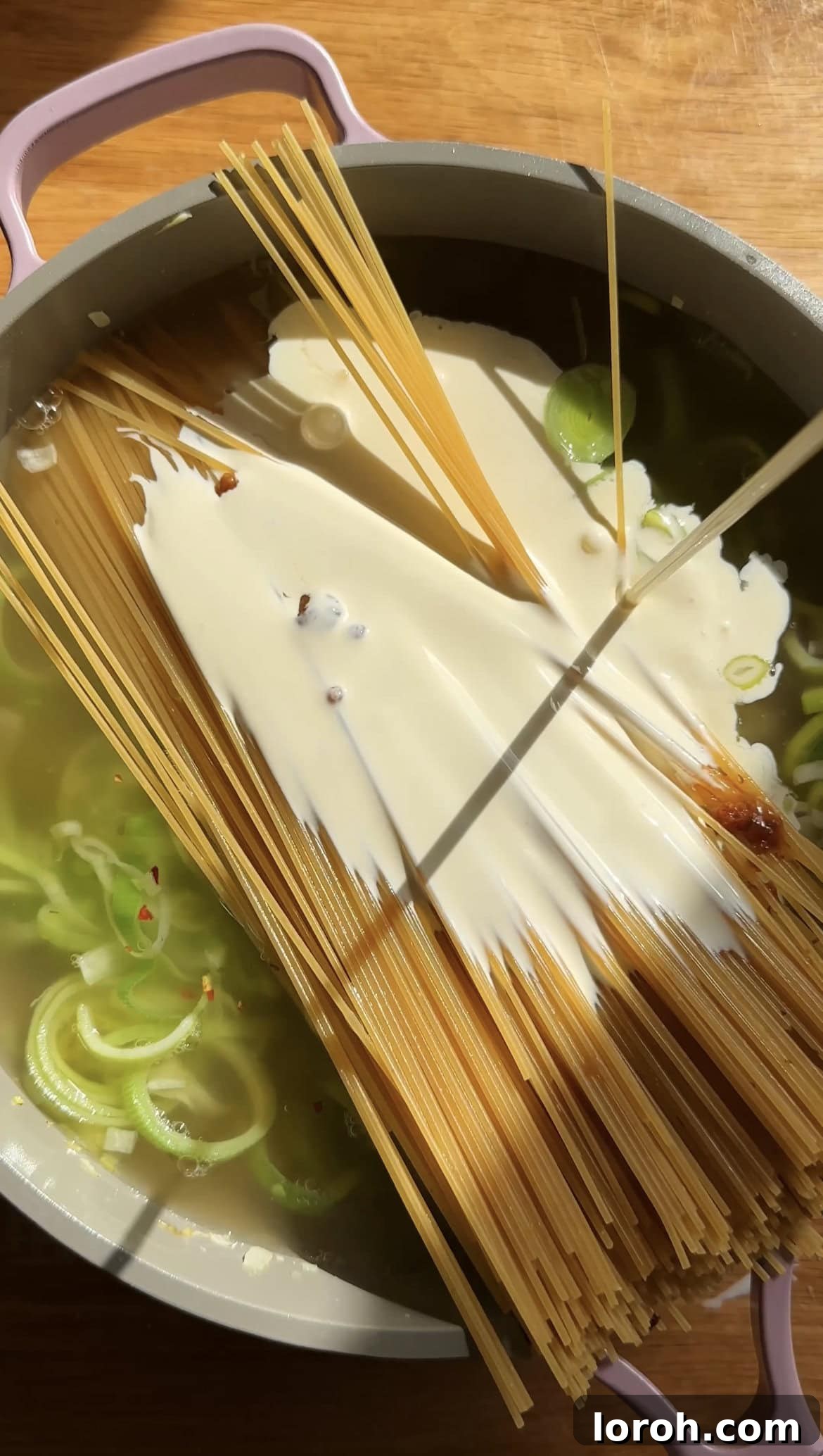 Sizzling Parma Ham & Leek One-Pan Pasta 6 Spaghetti cooking in creamy stock in a large saucepan, forming a rich sauce