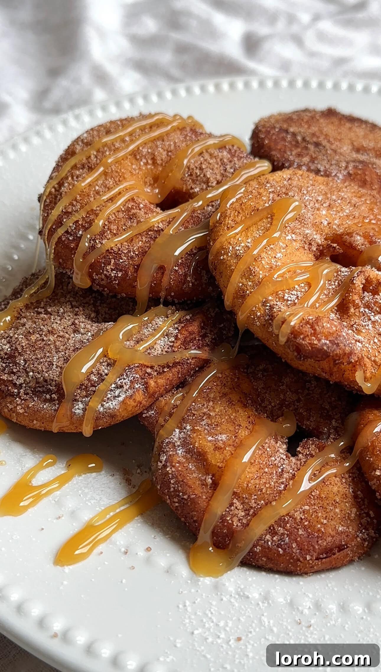 Apple Fritters 2 Crispy golden Apple Beignets, also known as Appelflappen, dusted with cinnamon sugar on a platter.