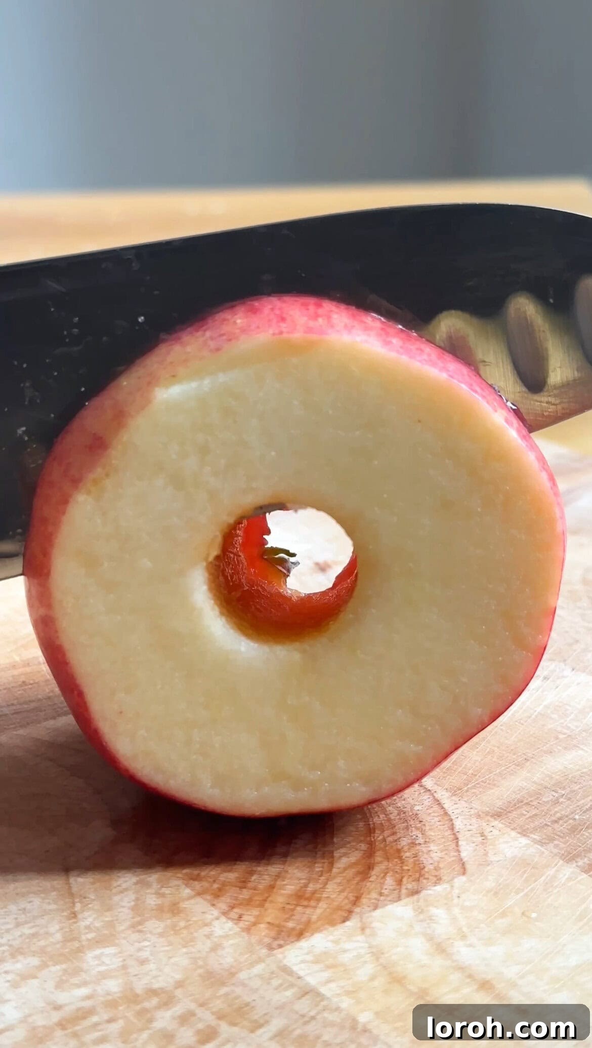 Apple Fritters 5 An apple being sliced into uniform rings after being cored.