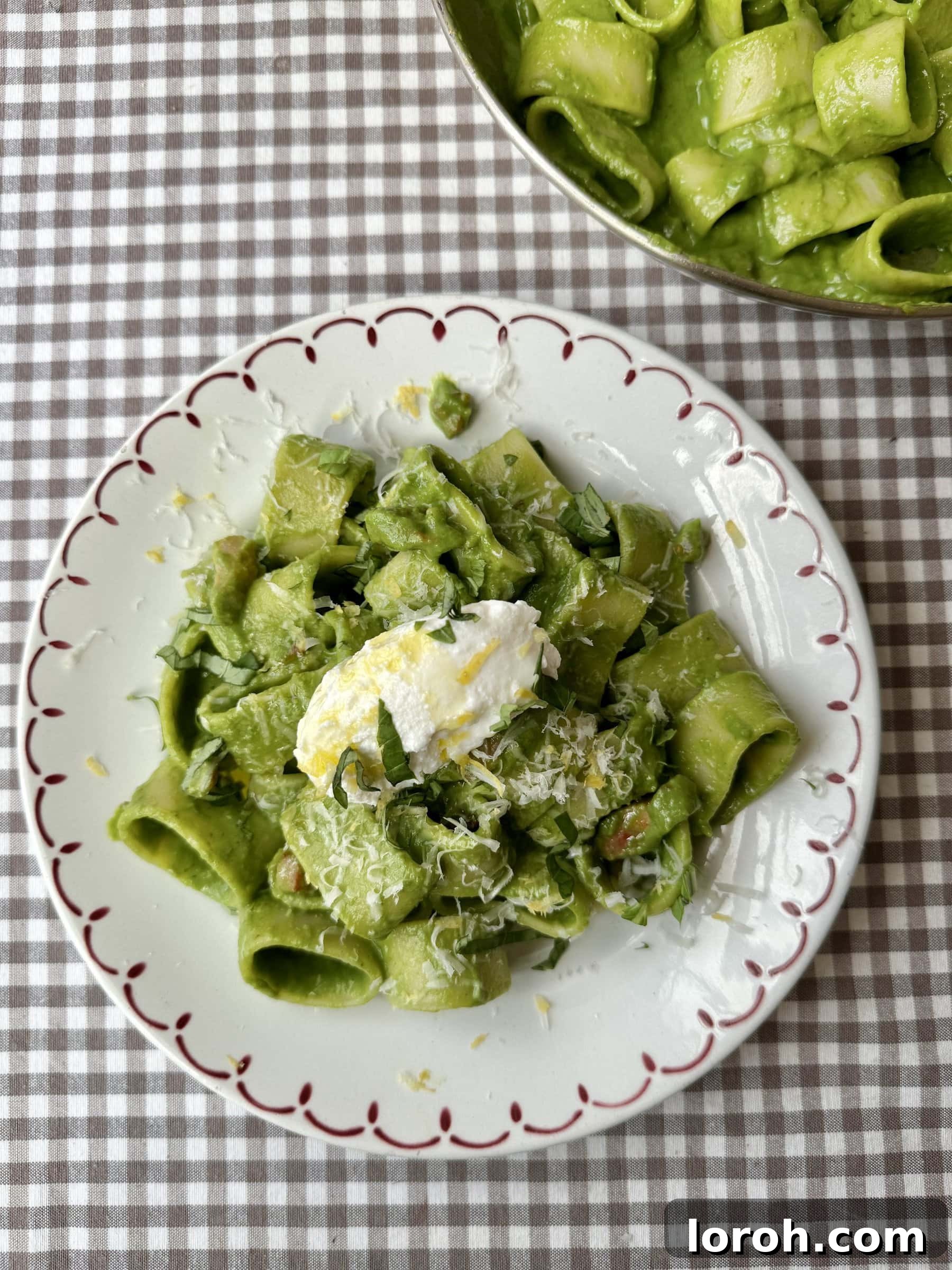 Another enticing view of the pasta in green sauce on a plate, garnished with more cheese.